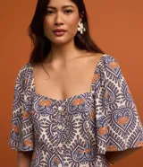 Vestido long midi de viscosa estampada con corazones y piñas, escote corazón, mangas cortas evasé, volado en el ruedo y botones delanteros.
