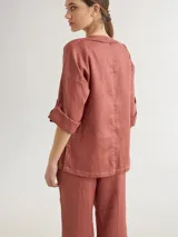 Camisa color coral de lino, corte holgado, escote redondo y mangas 3/4 ajustables con botón.