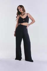 Pantalón negro de corte palazzo con cintura alta y elástica.