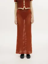 Falda larga de tejido calado color ladrillo, con cintura elástica.