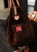 Bolso de viaje color verde oliva con detalles en cuero marrón.