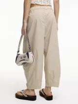 Pantalón negro tipo chino con pinzas delanteras, bolsillos laterales y pretina con elástico.