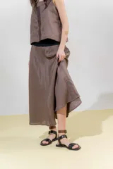 Falda midi de lino color gris claro, de silueta amplia y pretina elastizada color beige.
