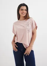 Remera rosa pálido de corte holgado con aplique de flores con strass.