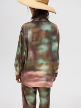 Camisa oversize de viscosa con estampado abstracto en tonos marrones, verdes y rosados. Tiene cuello clásico, manga larga y bolsillo cuadrado en el frente.
