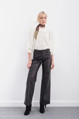 Pantalón de cuero ovino negro, de corte jeanero con calce oxford y tiro medio. Acceso delantero con botón metálico y cierre. Bolsillos delanteros y traseros.