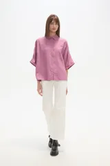 Camisa holgada de viscosa color rosado, con cuello camisero, manga corta y cierre frontal de botones.