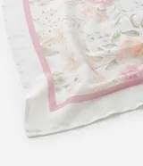 Pañuelo cuadrado de satén color blanco con estampado floral en tonos rosa y verde, y borde liso color rosa.