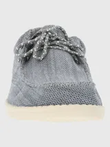 Alpargata negra con cordones elásticos y suela blanca con textura.