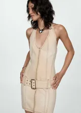 Vestido corto color beige, con cuello halter, cierre frontal con cremallera y cinturón con hebilla.