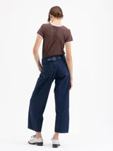 Jeans de denim azul oscuro, tiro alto, con calce slouchy y pierna ancha y corta. Presenta costuras curvas distintivas en el frente que definen la forma de la pierna.