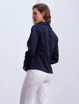 Camisa blanca de satén, marca Tahari. Cuello con solapa y escote en V. Abertura central con botones. Manga larga con puño y botón.