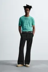 Pantalón negro de corte recto con bordados florales a tono, bolsillos laterales y traseros de vivo. Cierre frontal con cremallera y botón.