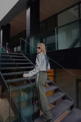 Pantalón ancho verde oliva con bolsillos cargo y aplique de cinta con rayas blancas en los laterales.