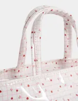 Lunchera tipo bolso con estampado escocés en tonos rosados y transparente. Tiene doble asa corta y etiqueta con logo en el frente.