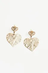 Aros colgantes dorados con forma de corazón calado y diseño abstracto.