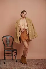 Abrigo doble botonado de tejido bouclé en color camel, con un diseño moderno y texturizado.