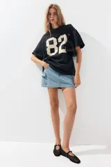 Remera oversized gris oscuro de punto suave de algodón con el número 82 estampado en blanco.