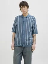 Polo de punto azul con rayas verticales blancas, cuello tipo camisa, cierre con botones y mangas cortas.