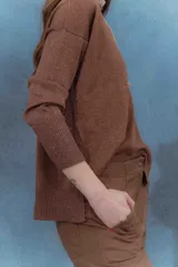 Sweater color beige de tejido de punto con brillo, escote en V y mangas largas.