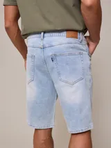 Bermuda de jean elastizado celeste, corte a la rodilla y tiro medio.