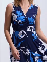 Vestido largo de seda fría con estampado floral en tonos azul y blanco. Tiene escote en V cruzado, cintura con faja plisada y detalles con relieve.