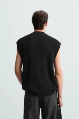 Chaleco negro de punto con cuello en V y sisas.