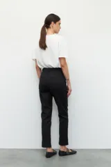 Pantalón de vestir color beige, de corte recto, con bolsillos laterales y traseros.