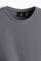 Remera gris de punto liviano con cuello redondo ribeteado y bajo recto. Corte ajustado que realza el contorno del cuerpo creando una silueta entallada. Confeccionada con tejido funcional COOLMAX®, una fibra exclusiva de poliéster de secado rápido que elimina la humedad y regula la temperatura corporal proporcionando un ajuste cómodo y suave.