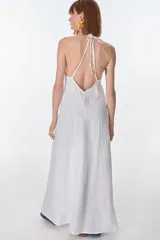 Conjunto de top halter con abertura en el abdomen y falda cruzada con ruedo desflecado, color fucsia.