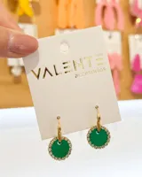 Aros colgantes dorados con dije circular verde esmeralda rodeado de strass.