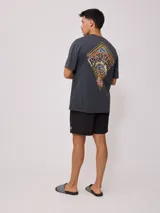 Remera de algodón con lavado, color celeste verdoso, de corte holgado (loose fit) y cuello redondo. Presenta un pequeño estampado gráfico en el pecho.