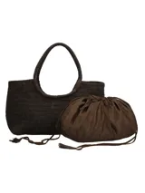 Bolso tipo tote de mimbre trenzado color marrón oscuro, con doble asa superior y parche de cuero con logo de la marca en el frente.
