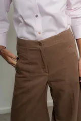 Pantalón marrón de tencel, corte ancho con pinzas y bolsillos laterales.