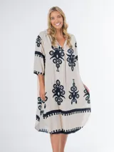 Vestido midi oversized con estampado en fondo negro, cuello tipo camisa, escote en V y tajos laterales.