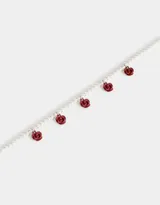 Collar corto de perlas blancas con dijes de rosas rojas.