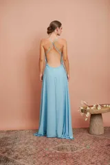 Vestido largo de fiesta celeste, con escote en V profundo y breteles finos. Presenta un detalle de frunce con aplique brillante en el centro del busto y falda acampanada.