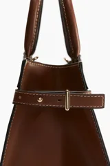 Cartera bandolera de lona color crudo con detalles en cuero marrón. Tiene doble asa corta y correa larga ajustable y extraíble.