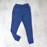 Jogger color azul piedra, confeccionado en algodón sin felpa, con tiro medio y puños ajustados.