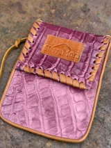 Cartera bandolera porta celular color marrón con textura croco y correa fina.