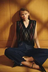 Pantalón de jean azul oscuro, de corte ancho y tobillero, con tiro alto, cinco bolsillos y cierre con botón.