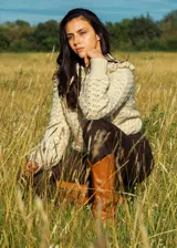 Sweater color crema tejido a crochet con lana merino, cuello alto con volados y mangas largas.