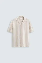 Camisa de hombre a rayas verticales color beige y blanco, de corte relaxed fit, manga corta y cuello bowling.