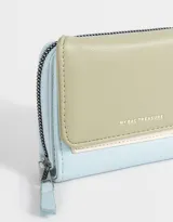 Billetera colorblock de cuerina con solapa con broche a presión, cierre y tirador.