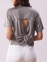 Blusa gris metalizada de tejido lurex, marca June & Hudson, con cuello redondo y ruedo con nudo en la espalda.