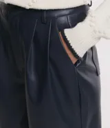 Pantalón pantalona confeccionado en material sintético con pliegues y bolsillos.