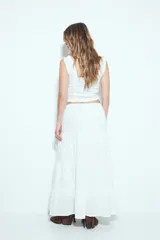 Falda larga maxi de algodón color marrón, con textura acanalada sutil. Presenta cintura elástica con cordón de ajuste y estructura en paños que añaden volumen y caída fluida.