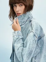Campera de jean celeste con efecto lavado, corte cropped, cuello camisero, cierre frontal con botones metálicos, cuatro bolsillos frontales con solapa y puños abotonados.