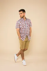 Camisa de manga corta con estampado a cuadros en tonos azul, rojo y blanco. Cierre con botones y tela ligera.