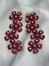 Par de aros colgantes con forma de flor color borgoña con apliques de strass.